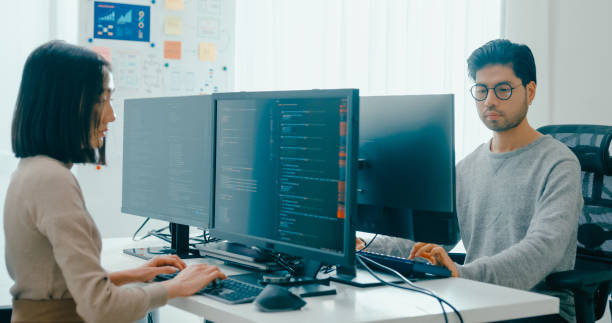 istock Group Asia male, female freelance typing write prompt AI bot IT app smart program nomad, video game, terminal with coding language, user interface, designer, big data center on desktop computer. 2166408519