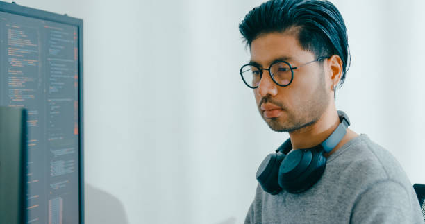 istock Closeup young adult Asia male freelance eyeglasses typing write prompt AI bot IT app program nomad, video game, terminal with coding, user interface, designer, big data center on computer. 2166408557