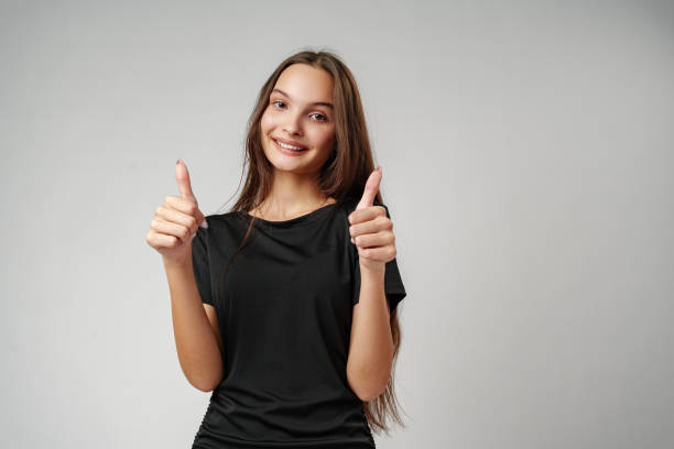 istock Young Woman Giving Thumbs Up in Studio 2166408843