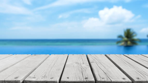 istock Wooden platform beside tropical infinity swimming pool 2166409267