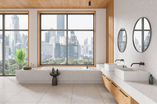istock Elegant hotel bathroom interior with double sink and bathtub, panoramic window 2166412301