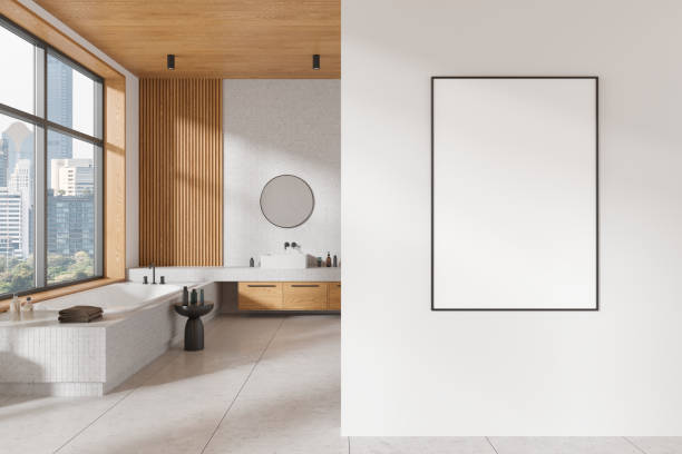 istock Modern bathroom with tub, vanity, and large window, featuring an empty frame on the wall. Minimalist design, wood and white background. Concept of interior design. 3D rendering 2166413321