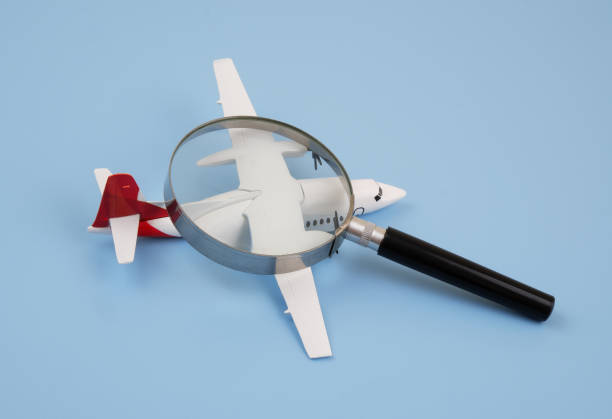 istock Airplane under magnifying glass on blue background. 2166416547