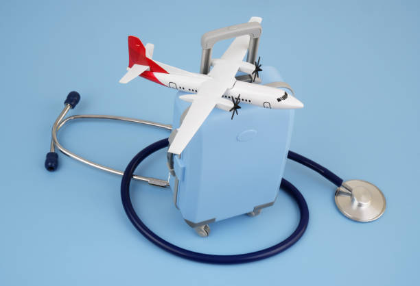 istock Airplane on suitcase and stethoscope on blue background. 2166416571