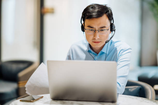 istock Asian businessman on videoconference with headset in modern office, capture the serious and contemplative emotions. 2166417151