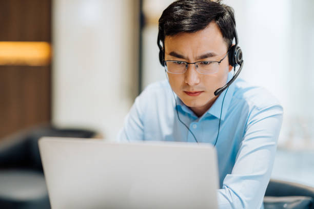 istock Asian businessman on videoconference with headset in modern office, capture the serious and contemplative emotions. 2166417465