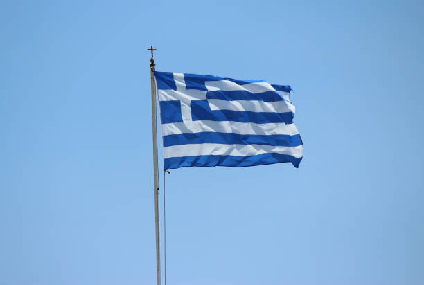 istock Greek flag waving against sky 2166417577