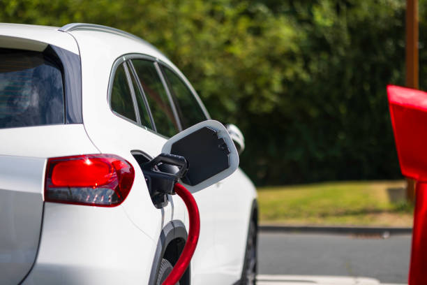 istock white electric car charging at charging station 2166418404