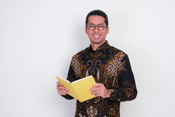 istock Indonesian teacher smiling happy while holding a book 2166423038