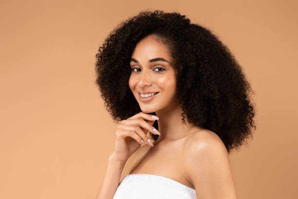 istock Smiling Young Woman With Posing Against a Tan Background 2166425780