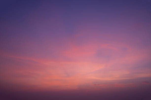 A beautiful sky with a pinkish hue. The sky is filled with clouds and the sun is setting