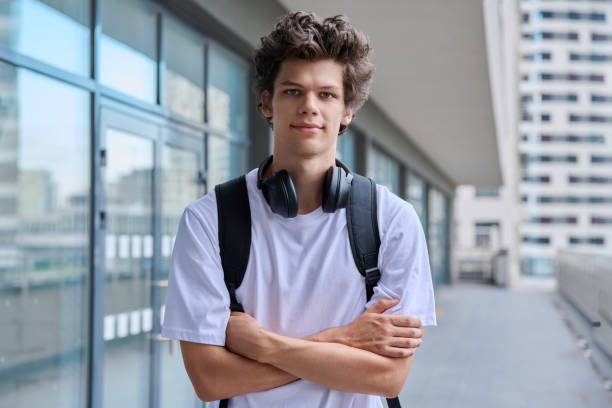 istock Handsome young man looking at camera outdoors, modern skyscrapers urban style background 2166429324