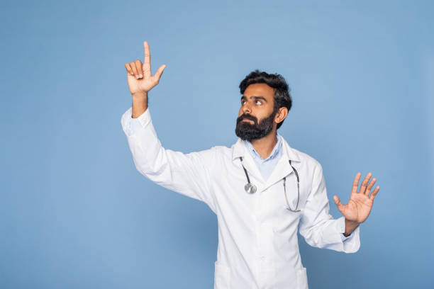 Bearded Doctor Gesturing Towards Something in Blue Studio Background