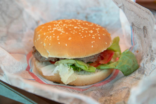 High angle view of a hamburger placed on a paper towel served on a tray at a restaurant.