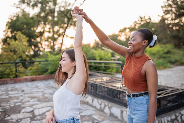 istock Two young women dancing in a park 2166433564