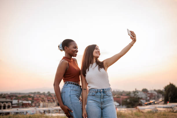 istock Young women taking selfies in a park 2166433569