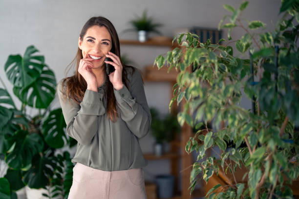 istock Smiling Woman Engaged in Phone Conversation in Office Setting 2166433592