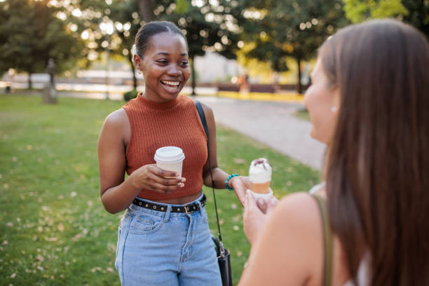istock Two friends talking to each other in a park 2166433784