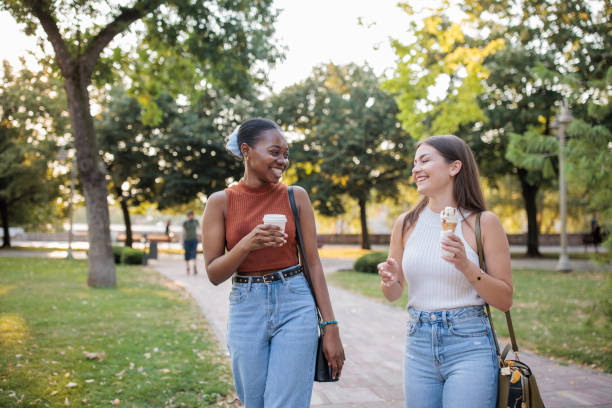 istock Two friends talking to each other in a park 2166433790