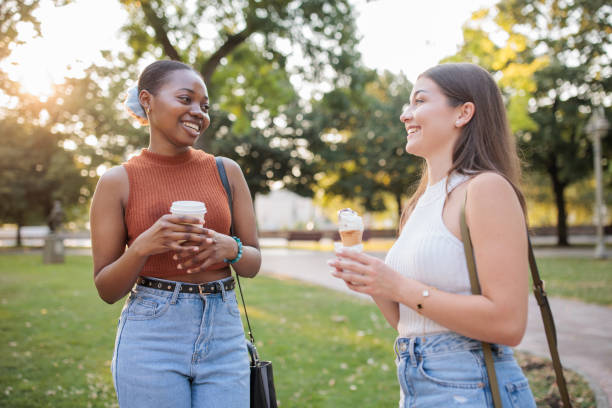 istock Two friends talking to each other in a park 2166433795