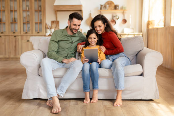 istock Happy family with tablet on a couch 2166434812
