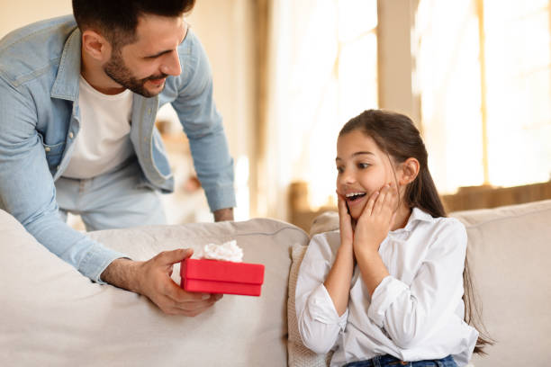 istock Man giving surprised girl a gift box 2166434848