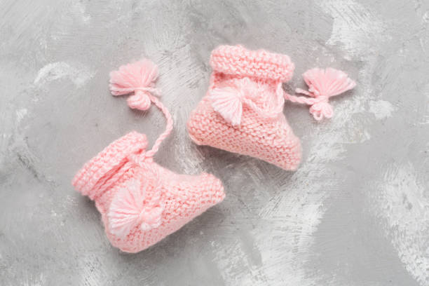 istock Pink baby booties on concrete background, top view 2166435922