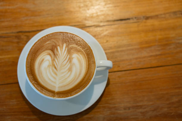 istock Hot latte art coffee in white ceramic cup on wooden table. 2166435972