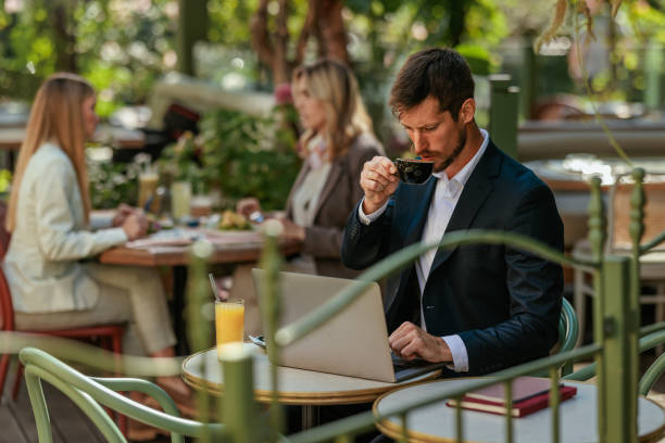 istock Man sipping coffee while working on his laptop 2166438396