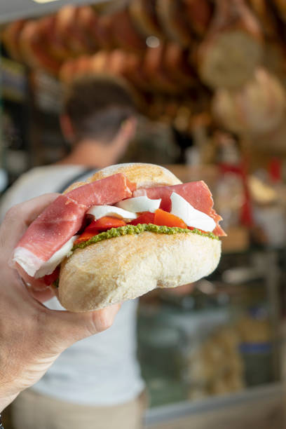 istock Sandwich with meat, vegetables and mozzarella in one hand 2166440990