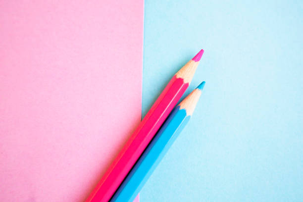 three colored pencils in front of a background of the same color
