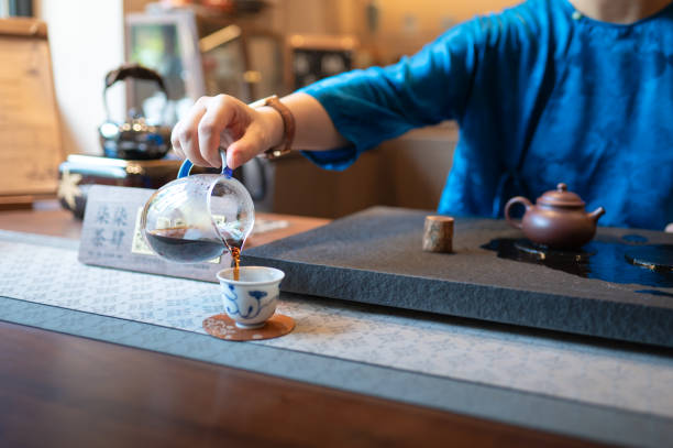 istock Pouring tea into a traditional cup during a tea ceremony, wearing a blue robe. 2166447437