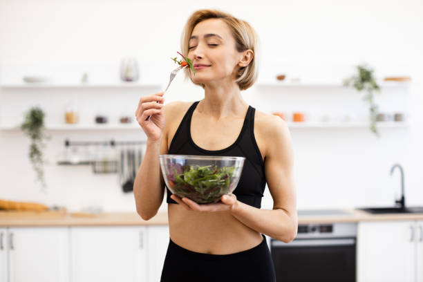 istock Woman enjoying fresh salad in modern kitchen 2166448773