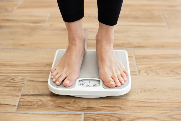 istock Person standing on scale checking body weight in gym 2166448866