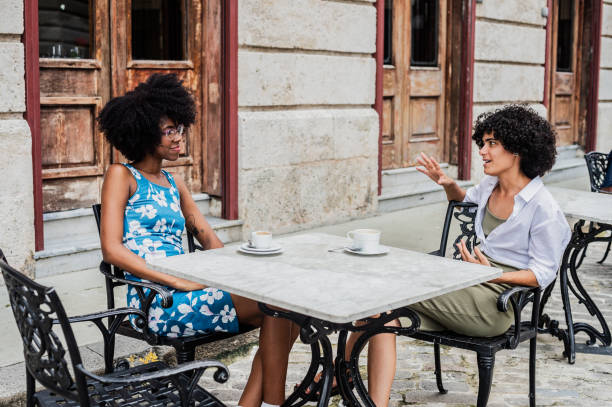 istock Young friends talking and drinking coffee at sidewalk cafe 2166449627