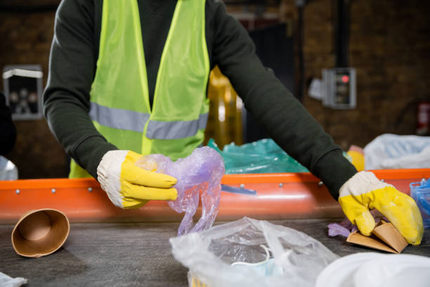 Volunteer diligently sorting waste to promote a cleaner and greener community in spring Dedicated volunteer sort through trash, fostering eco-consciousness for a sustainable future. sorter machine stock pictures, royalty-free photos & images