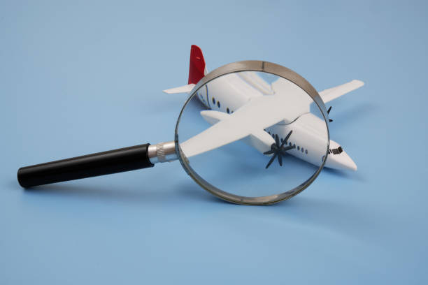 istock Airplane under magnifying glass on blue background. 2166450613