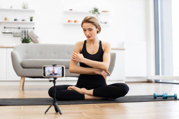 istock Woman doing yoga stretching exercise during online class 2166450912