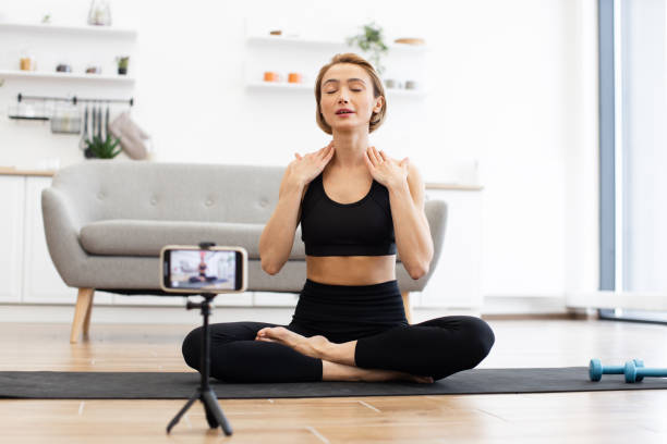 istock Woman practicing yoga at home with online class on phone 2166450921