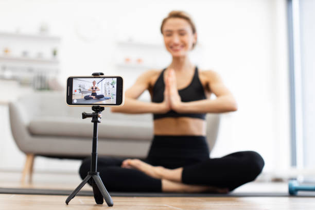 istock Woman practicing yoga at home recording online video tutorial 2166450936