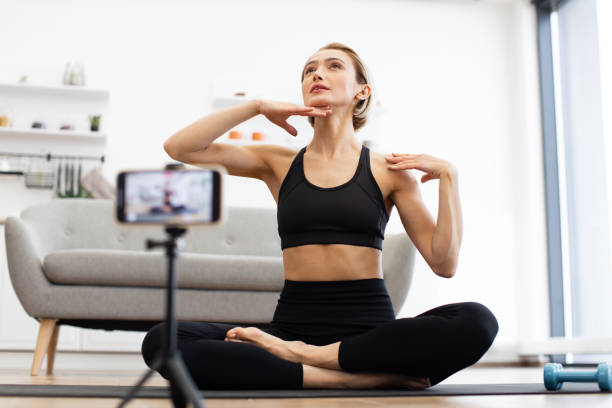 istock Woman filming yoga tutorial at home 2166450942