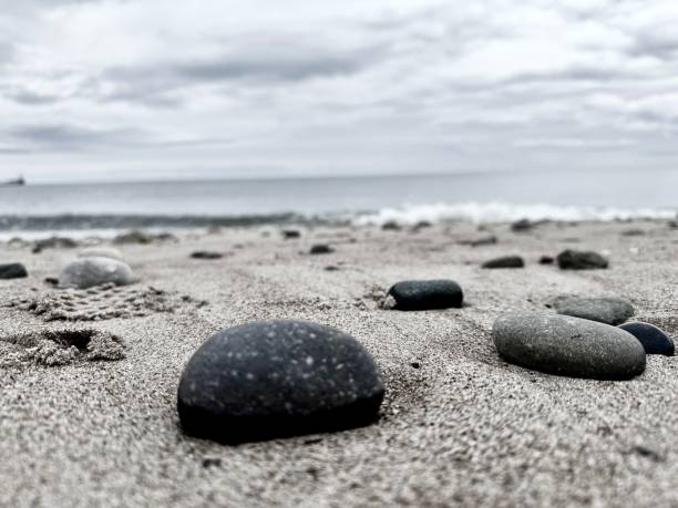 istock Rocks and pebbles on a sandy beach 2166451788