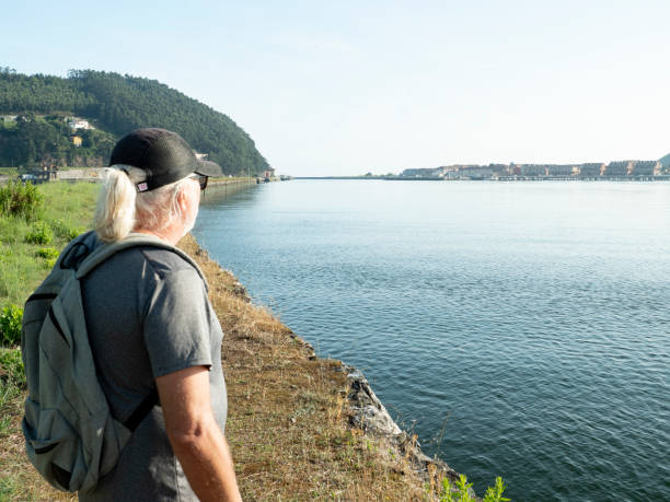 istock Cool middle aged man contemplating view over a river and a village 2166454623