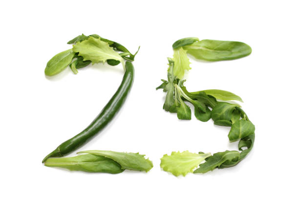 istock green anniversaries number 25, twenty five, from chilli pepper and salad lettuce leaf 2166463021