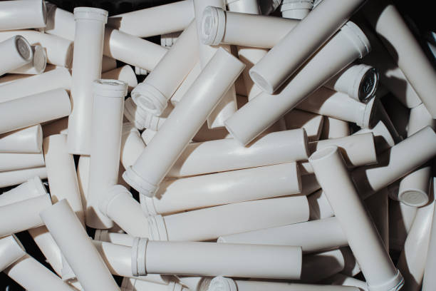 White tubes for tablets or capsules on the production line. Packaging for pharmaceutical products. Medication manufacturing.