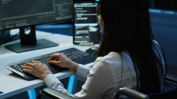 istock Person with paraplegia working in inclusive server hub workspace, typing on PC 2166471727