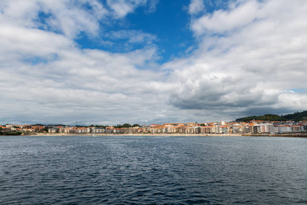 Panorama view of Sanxenxo and Silgar beach as seen from the sea on a cloudy Summer day in the Rias Baixas in Galicia, Spain.