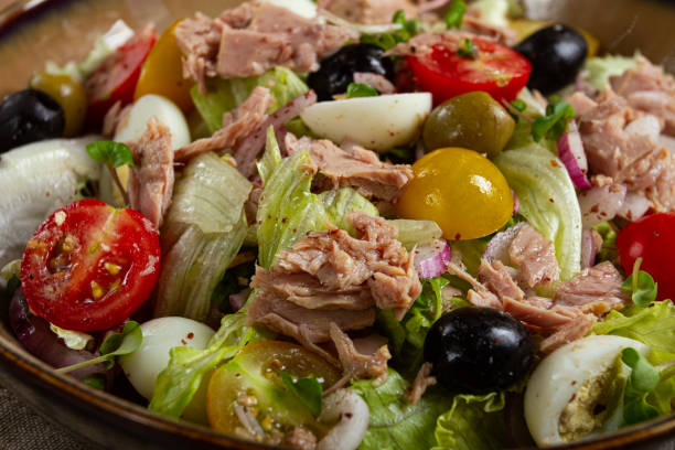 salad with canned tuna, vegetable salad with quail eggs, lettuce, red onion , cherry tomatoes , olives, keto food, healthy food, homemade, no people