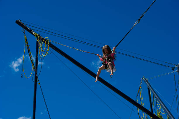 istock Young girl plays on high wire acrobatic equipment 2166477197