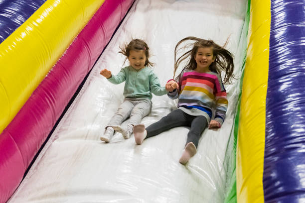 istock Young girls slide down inflatable slide 2166477267